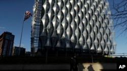 FILE - Armed British police officers patrol around the new United States Embassy building in London, Jan. 16, 2018. 