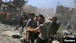 FILE - Men transport a casualty after what activists said were airstrikes by forces loyal to Syria's President Bashar al-Assad on a busy marketplace in Douma, near Damascus, Syria, Aug. 12, 2015. 