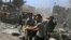FILE - Men transport a casualty after what activists said were airstrikes by forces loyal to Syria's President Bashar al-Assad on a busy marketplace in Douma, near Damascus, Syria, Aug. 12, 2015. 