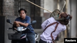 A long-tailed macaque attacks an worker  of a store  earlier  officials started capturing monkeys successful  Lopburi, Thailand, Feb. 3, 2024.