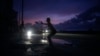 A woman prepares to catch a tossed flying disc during a massive blackout after a major power plant failed in Havana, Oct. 18, 2024.