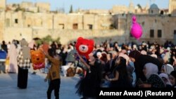 Anak-anak Palestina bermain saat sholat Idulfitri, di kompleks yang menampung masjid al-Aqsa, yang dikenal oleh Muslim sebagai Tempat Suci dan Orang Yahudi sebagai Temple Mount, di Kota Tua Yerusalem. 13 Mei 2021. (Foto: Reuters)