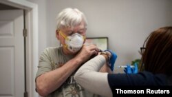 Fred Laredo, 72, receives the Moderna COVID-19 vaccination from Dr. Lishunda Franklin at Crescent City Pharmacy in New Orleans, Louisiana, Jan. 8, 2021.