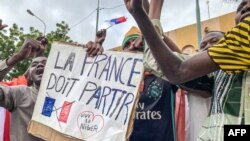 TOPSHOT - Protesters hold an anti-France placard during a demonstration on independence day in Niamey on August 3, 2023.