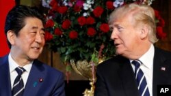 El presidente Donald Trump (derecha) y el primer ministro japonés Shinzo Abe, conversan durante una reunión en Mar-a-Lago, la mansión del mandatario estadounidense en Palm Beach, Florida. Abril 17 de 2018.