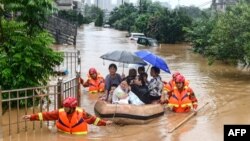 Tim penyelamat mengevakuasi warga yang terkena dampak banjir setelah hujan lebat di Jiujiang di provinsi Jiangxi di China, 8 Juli 2020. (Foto oleh STR / AFP) / China OUT