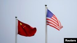 Bendera China dan AS berkibar di luar gedung kantor sebuah perusahaan di Shanghai, China, 14 April 2021. (Foto: Aly Song/Reuters)