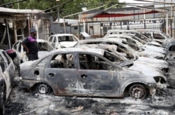 A man looks at cars that were burned during the latest spate of xenophobic attacks, at a car dealership in Johannesburg, South Africa, Sept. 5, 2019.