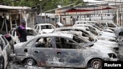 A man looks at cars that were burned during the latest spate of xenophobic attacks, at a car dealership in Johannesburg, South Africa, Sept. 5, 2019.