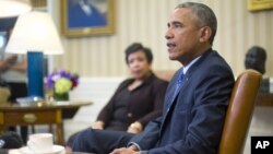 Attorney General Loretta Lynch listens as President Barack Obama speaks in the Oval Office of the White House in Washington, Jan. 4, 2016, during a meeting with law enforcement officials to discuss executive actions the president can take to curb gun violence.