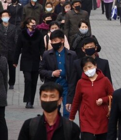 FILE - People wear face masks amid the concern over the spread of the coronavirus in Pyongyang, North Korea, April, 1, 2020.