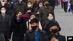 FILE - People wear face mask amid the concern over the spread of the coronavirus in Pyongyang, North Korea, April, 1, 2020. 