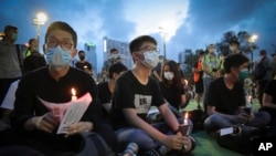 លោក Joshua Wong សកម្មជន​លទ្ធិ​ប្រជាធិបតេយ្យ​នៅ​ក្នុង​ក្រុង​ហុងកុង (រូប​កណ្តាល) កាន់​ទៀន​ នៅ​ពេល​លោក​ចូលរួម​ជាមួយ​អ្នក​ដទៃ​ទៀត​សម្រាប់​កម្មវិធី​អុជទៀន​រំឭក​ដល់​ជន​រងគ្រោះ​នៃ​ការ​បង្ក្រាប​នៅ​ទីលាន Tiananmen ក្នុង​ឆ្នាំ១៩៨៩ នៅ​ឧទ្យាន Victoria ក្នុង​ក្រុង​ហុងកុង កាលពី​ថ្ងៃទី៤ ខែមិថុន