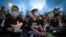Hong Kong democracy activist Joshua Wong, center, holds a candle as he joins others for a vigil to remember the victims of the 1989 Tiananmen Square Massacre at Victoria Park in Causeway Bay, Hong Kong, June 4,2020. 