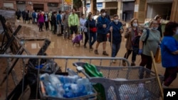 Residents wait to receive drinking water in an area, affected by floods, in Paiporta, Valencia, Spain, Nov. 5, 2024.