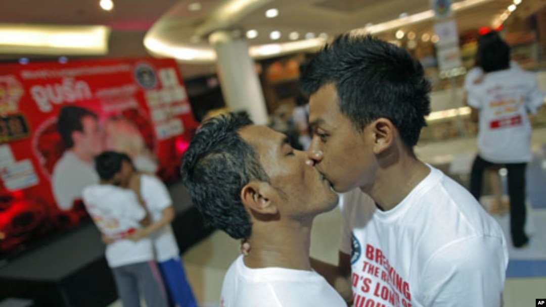Men kiss among other couples participating in the Guinness World Record attempt in the longest continuous kiss in Pattaya, Thailand, February 12, 2012.