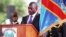 FILE - Incumbent Congo President Joseph Kabila holds the Congolese flag as he takes the oath of office as he is sworn in for another term, in Kinshasa, Democratic Republic of Congo.
