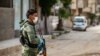 FILE - A member of the Kurdish Internal Security Forces of Asayesh stands guard on a deserted street in Syria's northeastern city of Hasakah.