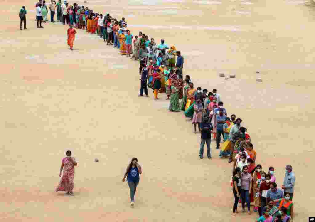 Hundreds of people line up to receive their second dose of vaccine against the coronavirus at the municipal ground in Hyderabad, India.
