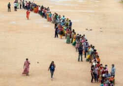 Hundreds of people line up to receive their second dose of vaccine against the coronavirus at the municipal ground in Hyderabad, India, July 29, 2021.