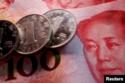 FILE - Coins and banknotes of China's yuan are seen in this illustration picture taken February 24, 2022.