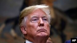 FILE - President Donald Trump attends a ceremony before signing an executive order establishing the White House Opportunity and Revitalization Council, in the Roosevelt Room of the White House.