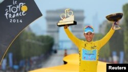 Pebalap sepeda Italia Vincenzo Nibali mengangkat trophy Tour de France dalam upacara di Champs Elysees di Paris Minggu (27/7).