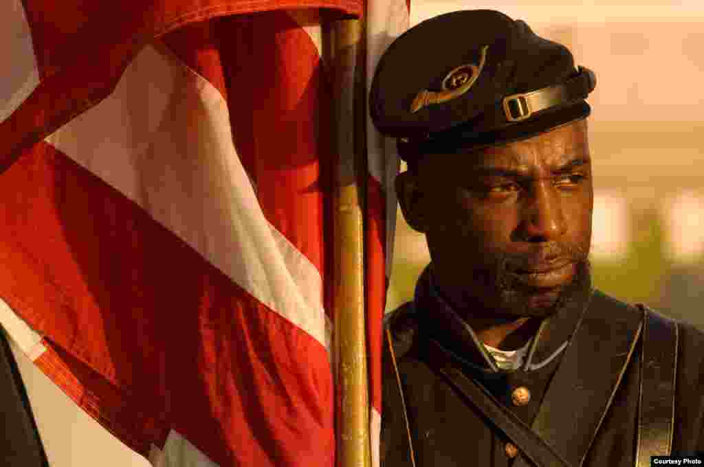 A Union soldier reenactor stands by an 1864 U.S. flag at Gettysburg&#39;s Lincoln Cemetery on Remembrance Day. A special ceremony is held for black soldiers who continue to be buried there. (&copy; Kenneth Garrett Photography)