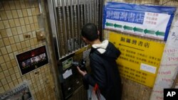 A mainland Chinese tourist checks the door of the closed Causeway Bay Bookstore which is known for gossipy titles about Chinese political scandals and other sensitive issues that are popular with visiting tourists from the mainland, in Hong Kong, Feb. 5, 2016. 