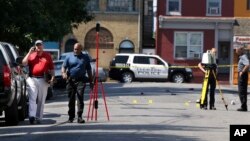 El fiscal del Condado Mercer, Nueva Jersey, Angelo Onofri (izquierda) camina junto a investigadores en una calle cerca del edificio donde se realizaba el festival de arte Art All Night en Trenton el domingo, 17 de junio de 2018.