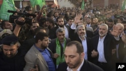 12月7日在加沙城，哈马斯流亡领袖梅沙尔（左）和加沙的哈马斯总理哈尼耶香民众挥手