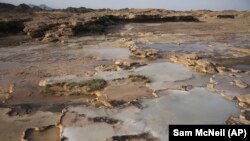 This March 5, 2017 photo shows travertine pools with white films of carbon fused with calcium, a chemical process being explored by a geological research project, in the al-Hajjar mountains of Oman. (AP Photo/Sam McNeil)