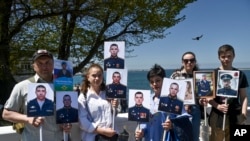 Rodbina vojnika koji su poginuli tokom ruske specijalne vojne operacije u Donbasu poziraju za fotografiju držeći njihove portrete