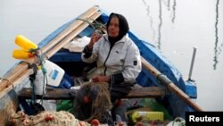 Chrifa Nimri arranges a net after returning from fishing at the seaport Sidi Bou Said, in Tunis.