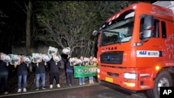 Trabajadores de un centro de conservación de la provincia china de Sichuan despiden a dos pandas gigantes enviados a Washington, el 14 de octubre de 2024.