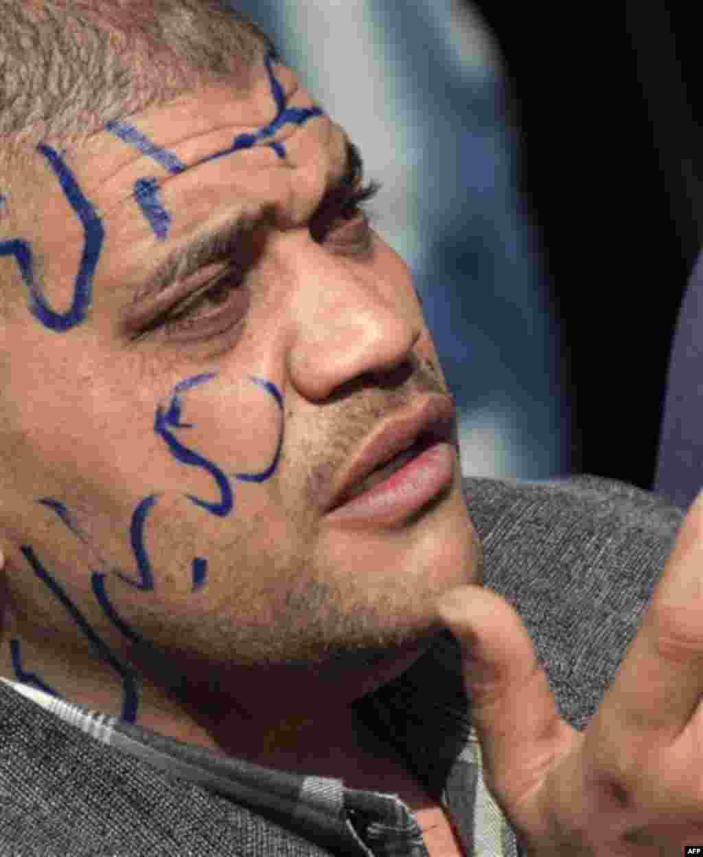 An Egyptian pro-Mubarak supporter with "Mubarak" written on his face prays during march in Cairo, Egypt, Tuesday, Feb. 1, 2011. Egyptian authorities battled to save President Hosni Mubarak's regime with a series of concessions and promises to protesters, 