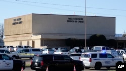 FILE - Law enforcement vehicles are seen parked outside West Freeway Church of Christ as authorities investigate a fatal shooting at the church, in White Settlement, Texas, Dec. 29, 2019.