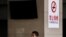 FILE - A Chinese man smokes in front of a pillar with a no smoking notice on display at a bus station in Beijing, March 24, 2011