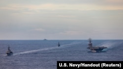 Japan Maritime Self-Defense Force training ships JS Kashima and JS Shimayuki conduct a passing exercise (PASSEX) with Nimitz-class nuclear-powered aircraft carrier USS Ronald Reagan in the South China Sea, July 7, 2020. (U.S. Navy/Handout via REUTERS)