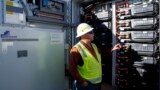 FILE - Mike Vandrely, construction manager, checks on a battery storage pod at Orsted's Eleven Mile Solar Center lithium-ion battery storage energy facility Thursday, Feb. 29, 2024, in Coolidge, Ariz. (AP Photo/Ross D. Franklin)