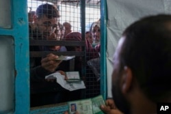 FILE - Palestinians enactment     up   to person   assistance  distributed by UNRWA, the U.N. bureau  helping Palestinian refugees, successful  Nusairat exile  camp, Gaza, Nov. 5, 2024.