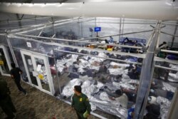 FILE - Minors lie inside a pod at the Donna Department of Homeland Security holding facility, the main detention center for unaccompanied children in the Rio Grande Valley run by U.S. Customs and Border Protection, in Donna, Texas, March 30, 2021.