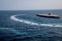 28일 이란 혁명수비대가 호르무즈해협에서 미 해군 항공모함 모형 구조물을 동원해 군사훈련을 하고 있다.