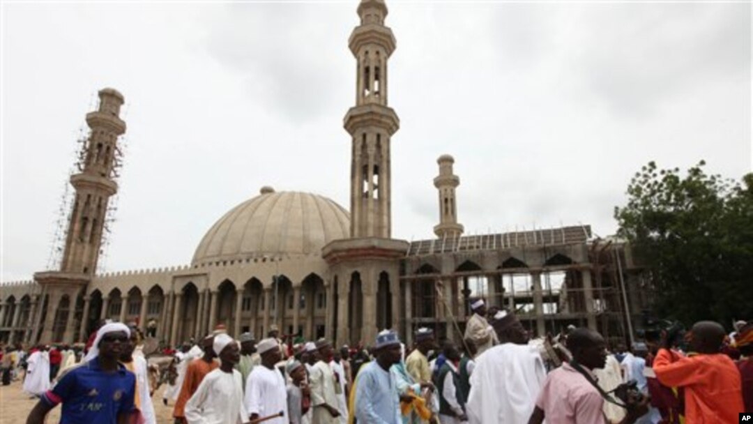 Warga Muslim Nigeria berjalan melewati sebuah masjid di Maiduguri, Nigeria, pada hari raya Idul Fitri.