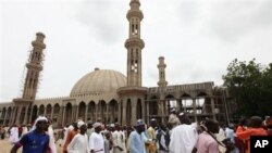 Warga Muslim Nigeria berjalan melewati sebuah masjid di Maiduguri, Nigeria, pada hari raya Idul Fitri.