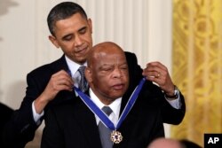 FILE - Former President Barack Obama presents a 2010 Presidential Medal of Freedom to U.S. Rep. John Lewis, D-Ga., during a ceremony in the East Room of the White House in Washington,Feb. 15, 2011.