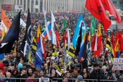 People hold various banners and flags during a rally to support political prisoners in Moscow, Russia, Sunday, Sept. 29, 2019.