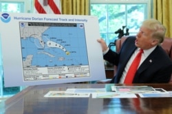 U.S. President Donald Trump holds a projected track of Hurricane Dorian map that appears to have been extended to Florida and parts of Alabama during a meeting on the hurricane in the Oval Office of the White House in Washington, Sept. 4, 2019.