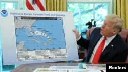 U.S. President Donald Trump holds a projected track of Hurricane Dorian map that appears to have been extended to Florida and parts of Alabama during a meeting on the hurricane in the Oval Office of the White House in Washington, Sept. 4, 2019.