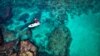 A man dressed with a Santa Claus outfit rides on a standup paddle in Lebanon&#39;s northern coastal city of Batroun.